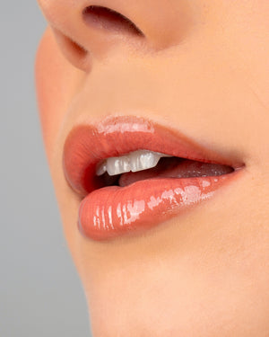 Close-up of lips wearing Ohana&K Vegan and Cruelty-Free Lip Gloss in Peach Pearl, showcasing a glossy, peach-toned finish with a subtle shimmer.