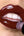 Close-up of lips wearing Ohana&K Vegan and Cruelty-Free Lip Gloss in Smoked Paprika, showing a warm red glossy finish that enhances natural lip color.